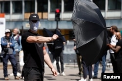 Göstericiler, medya tarafından görüntülenmemek için siyah şemsiye açtı.