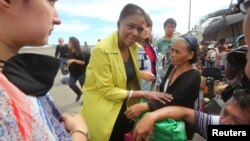 United Nations Under-Secretary General for Humanitarian Affairs, Valerie Amos (C), speaks to typhoon survivors at the airport in Tacloban, central Philippines, Nov. 13, 2013.