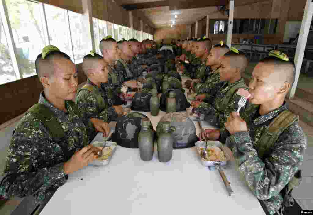 菲律賓海軍陸戰隊新入伍的女兵2013年2月5日在馬尼拉以南甲米地市的特爾納特鎮的海軍陸戰隊總部同戰友們共進午餐。