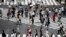People wearing a protective face mask to help curb the spread of the coronavirus walk at Shibuya pedestrian crossing Thursday, July 9, 2020, in Tokyo. 