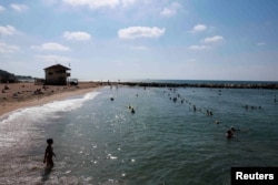 Orang-orang berenang di Laut Mediterania, di Haifa, Israel utara, di tengah meningkatnya ketegangan selama konflik di Gaza, 31 Juli 2024. (Ammar Awad/REUTERS)