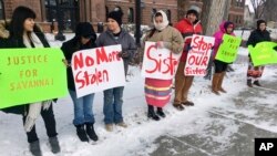 FILE - Demonstrators stand outside the Cass County Courthouse in Fargo, N.D., Dec. 6, 2017, during the trial of those accused of killing of 22-year-old Savanna Greywind of Fargo. The protesters were hoping to draw attention to unsolved killings of indigenous women.