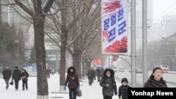 북한이 핵실험을 강행한 12일 오후 북한 시민들이 '장엄한 진군'이라고 쓰인 현수막이 내걸린 평양 거리를 걷고 있다.