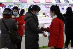 지난달 28일 북한 평양제1백화점 직원들이 입장객들의 체온을 재고 있다.