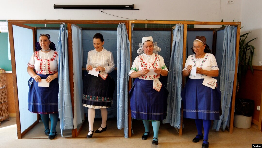 Hungarian women wearing traditional costume leave a voting booth at a polling station during a referendum on EU migrant quotas, Oct. 2, 2016. Both sides claimed victory as the vote was declared not valid.