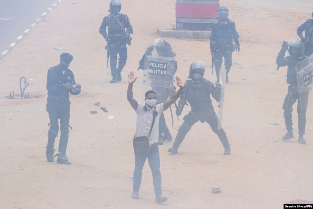 Um manifestante p&#245;e as m&#227;os no ar enquanto se afasta da pol&#237;cia, durante a manifesta&#231;&#227;o anti-governo em Luanda. A pol&#237;cia anti-motim, alguns montados em cavalos, disparou g&#225;s lacrimog&#233;neo e agrediu dezenas de manifestantes que tomaram as ruas da capital a