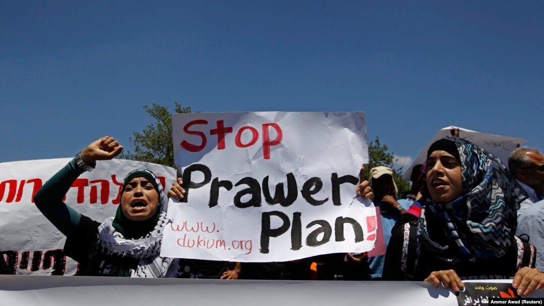 Bedouins hold signs as they take part in a protest against a plan to formally recognise Bedouin communities in the Negev desert, outside the Knesset, the Israeli parliament, in Jerusalem May 27, 2013. 
