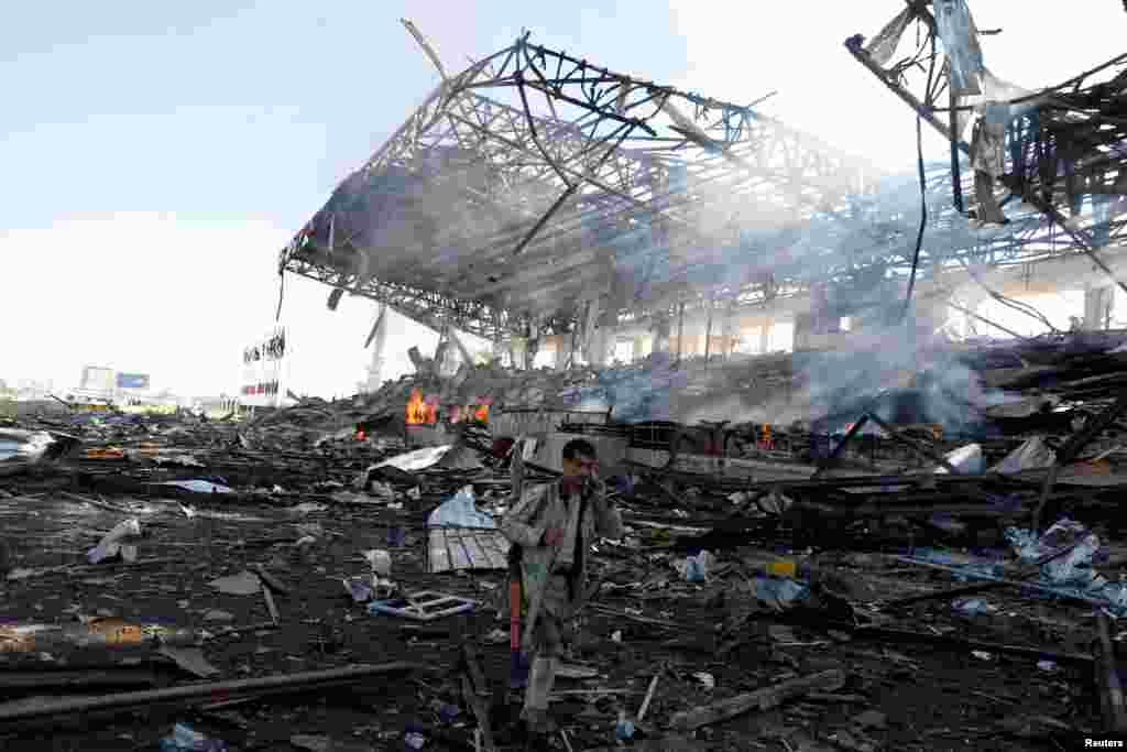 A Houthi fighter talks on the phone as he walks at the site of an airstrike on a parade square in Sana&#39;a, Yemen, Nov. 5, 2017.