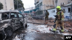 نیروهای پلیس و امدادی اسرائيل در محل اصابت یک راکت شلیک شده از غزه و در کنار خودرویی آسیب دیده - ۱۷ مهر ۱۴۰۲