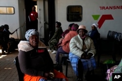 Patients queue for an eye test, outside the Phelophepa eye clinic carriage, in Tembisa, east of Johannesburg, South Africa, Thursday, Aug. 22, 2024. (AP Photo/Themba Hadebe)