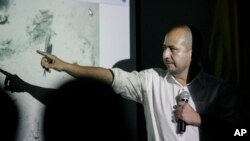 Ernesto Montenegro, director of the Colombian Institute of Anthropology and History of Colombia, talks to reporters while he shows a picture of remains of the galleon San Jose in Cartagena, Colombia, Dec.5, 2015.