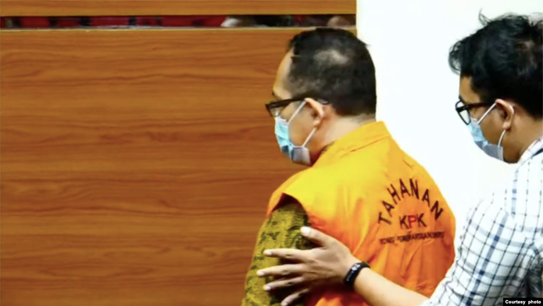 Petugas KPK mengarahkan Hakim Itong Isnaeni Hidayat agar tenang dalam konferensi pers mengenai Operasi Tangkap Tangan (OTT) di Pengadilan Negeri Surabaya, di Jakarta, pada 20 Januari 2022. (Foto: Tangkapan layar)
