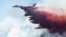 A plane drops fire-retardant chemicals on the 416 Fire near Durango, Colorado, June 9, 2018.