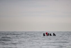 Migrantes navegan en un barco en aguas agitadas entre Sangatte y Cap Blanc-Nez, en el Canal de la Mancha frente a la costa del norte de Francia, mientras intentan cruzar las fronteras marítimas entre Francia y el Reino Unido, el 27 de agosto de 2020.