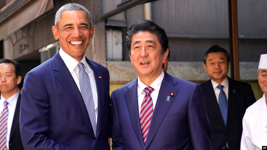 Mantan Presiden AS Barack Obama (kiri) dan PM Jepang Shinzo Abe berpose di depan restoran sushi "Kyubey" di Ginza, Tokyo, Minggu (25/3). 