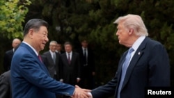 资料照片：美国总统唐纳德·特朗普在参观完北京中南海花园后离开时与中国国家主席习近平握手。（2026年5月15日）