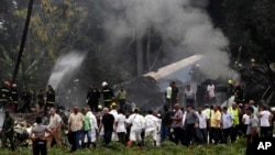 FILE - Cuba's President Miguel Diaz-Canel, third from left, walks away from the site where a Boeing 737 plummeted into a yuca field in Havana, Cuba, May 18, 2018.