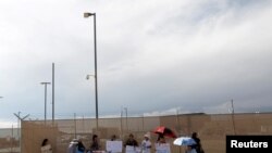 Activistas sostienen pancartas en favor de niños inmigrantes a las afueras del centro de detención de Clint, Texas, en julio de 2019.