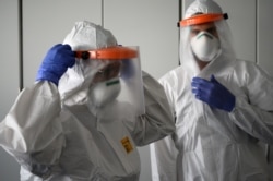 Nurses put on their Personal Protective Equipment (PPE) before starting to work on the preparation of the Intensive care unit in the new Covid-19 Hospital on March 29, 2020 in Verduno, near Alba, Northwestern Italy.