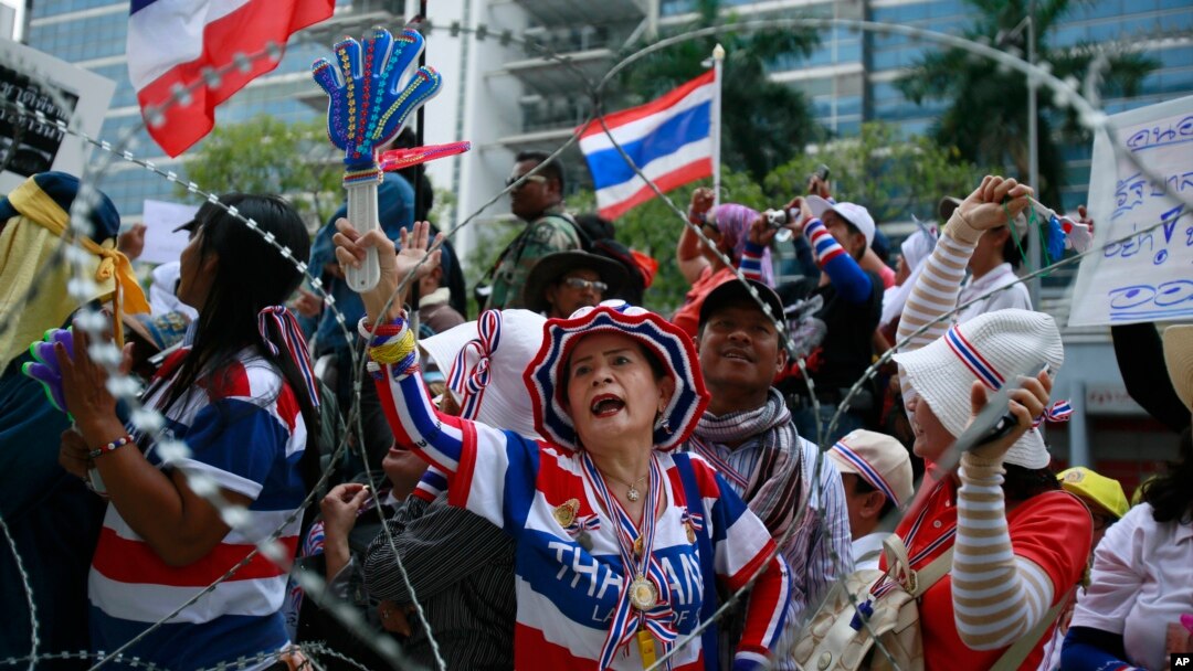 Demonstran anti-pemerintah Thailand meneriakkan keinginan mereka agar PM Yingluck Shinawatra mundur dari jabatannya, dari luar kantor sementara Yingluck di kantor Kementerian Pertahanan Thailand di Bangkok, Thailand (19/2).