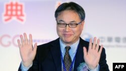 China Mobile Chief Executive Li Yue waves to the press during a ceremony in Taipei linking the first undersea fiber optic cable between Taiwan and China on January 18, 2013. 