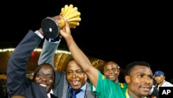 Le capitaine zambien Christopher Katongo, à droite, et le président de la Fédération zambienne de football Kalusha Bwalya, brandissent le trophée de la CAN 2012 après leur victoire contre la Côte d'Ivoire à Libreville, Gabon, le 12 février 2012.