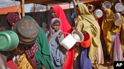 FILE - Women who fled drought queue to receive food at a camp for internally displaced persons, in the Daynile neighborhood on the outskirts of the capital Mogadishu, Somalia, May 18, 2019. 