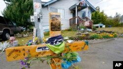 A sign that reads "Gone but not forgotten" is shown on a cross displayed May 27, 2021, at a memorial that has been established at the intersection in Tacoma, Wash., where Manuel Ellis died on March 3, 2020.