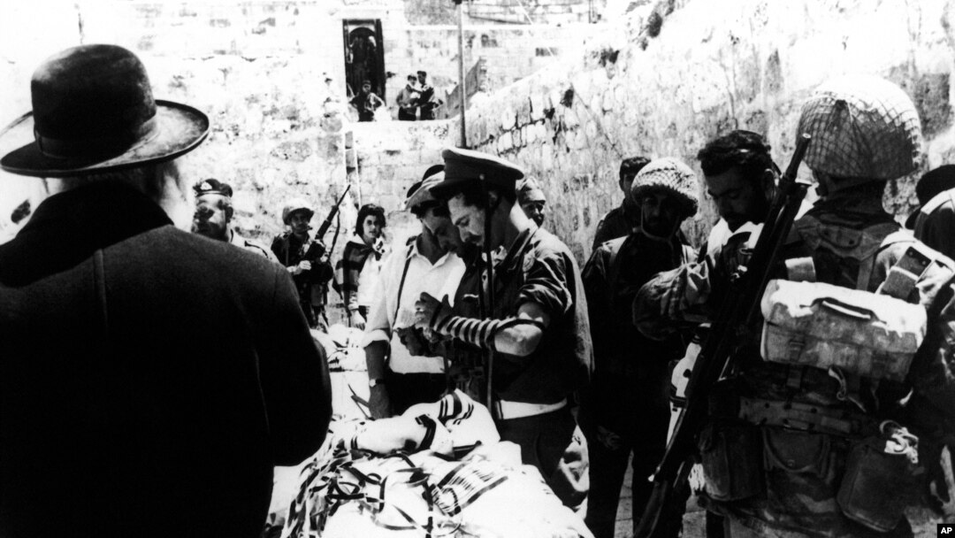 Arhiva - Na fotografiji od 8. juna 1967. ortodoksni Jevrejin nudi molitveni šal izraelskim vojnicima koji se mole kod Zida plača u Jerusalimu u Izraelu dan nakon šestodnevnog rata (AP Photo)