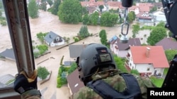 Pripadnik slovenačke vojske u helikopteru iznad Škofja Loke blizu Ljubljanje (Foto: Reuters)