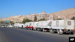 Un convoi d'aide humanitaire en face de l'Office de secours et de travaux des Nations Unies (UNRWA) avant son départ pour les villes assiégées de Madaya, al-Zabadani et al-Moadhamiya dans la région de Damas en Syrie, le 17 février 2016. (Photo AP) 