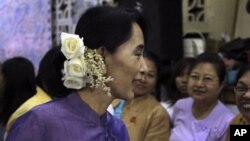 Burma democracy icon Aung San Suu Kyi talks to supporters before celebrations for the 96th birthday anniversary of her late father, General Aung San, and Myanmar Children Day at her National League for Democracy party's headquarters, in Rangoon, February 