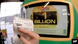 Seorang pelanggan memamerkan tiket yang baru saja dibelinya di kios penjualan tiket undian lotere Mega Million di Cranberry Township, Pennsylvania, 22 Januari 2021. (AP Photo/Keith Srakocic)