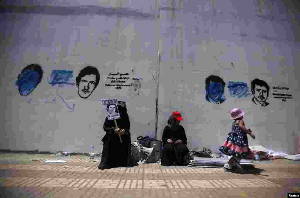 Relatives sit under pictures of disappeared political figures, putting focus on people who have disappeared in what is known as the "forced disappearance", in Sanaa September 27, 2012. 