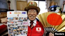 Naotoshi Yamada berpose dengan berbagai suvenir Olimpiade dan busana khasnya di kantornya di Tokyo, 3 Oktober 2018. (Foto: Reuters/Toru Hanai) 