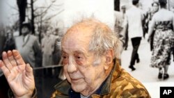 FILE - Photographer and filmmaker Robert Frank waves to a packed audience at the opening of the exhibition featuring his work, "Robert Frank: Books and Films, 1947–2016," at New York University's Tisch School of the Arts, Jan. 28, 2016, in New York.