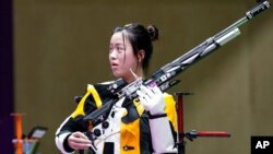 Yang Qian, of China, reacts after winning the gold medal in the women's 10-meter air rifle at the Asaka Shooting Range in the 2020 Summer Olympics, July 24, 2021, in Tokyo, Japan. 
