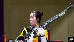 Yang Qian, of China, reacts after winning the gold medal in the women's 10-meter air rifle at the Asaka Shooting Range in the 2020 Summer Olympics, July 24, 2021, in Tokyo, Japan. 