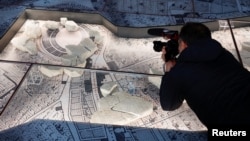 Un camarógrafo fotografía el Coliseo dentro de un mapa de mármol romano creado por orden del emperador Septimio Severo, en el museo Forma Urbis durante la inauguración del nuevo Celio Antiquarium, cerca del Coliseo en Roma, Italia, el 11 de enero de 2024.