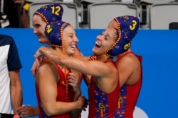 Spain's Marta Bach (2) and Pili Pena (8) celebrate after a win over South Africa in a preliminary round women's water polo match at the 2020 Summer Olympics, July 24, 2021, in Tokyo, Japan.