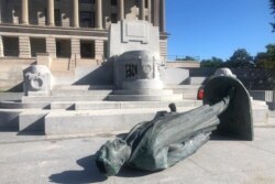 FILE - Protesters toppled the statue of Edward Carmack outside the state Capitol after a peaceful demonstration turned violent, in Nashville, Tenn., May 31, 2020.