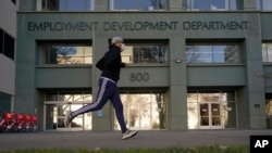 In his Dec. 18, 2020 file photo a runner passes the office of the California Employment Development Department in Sacramento, Calif. 
