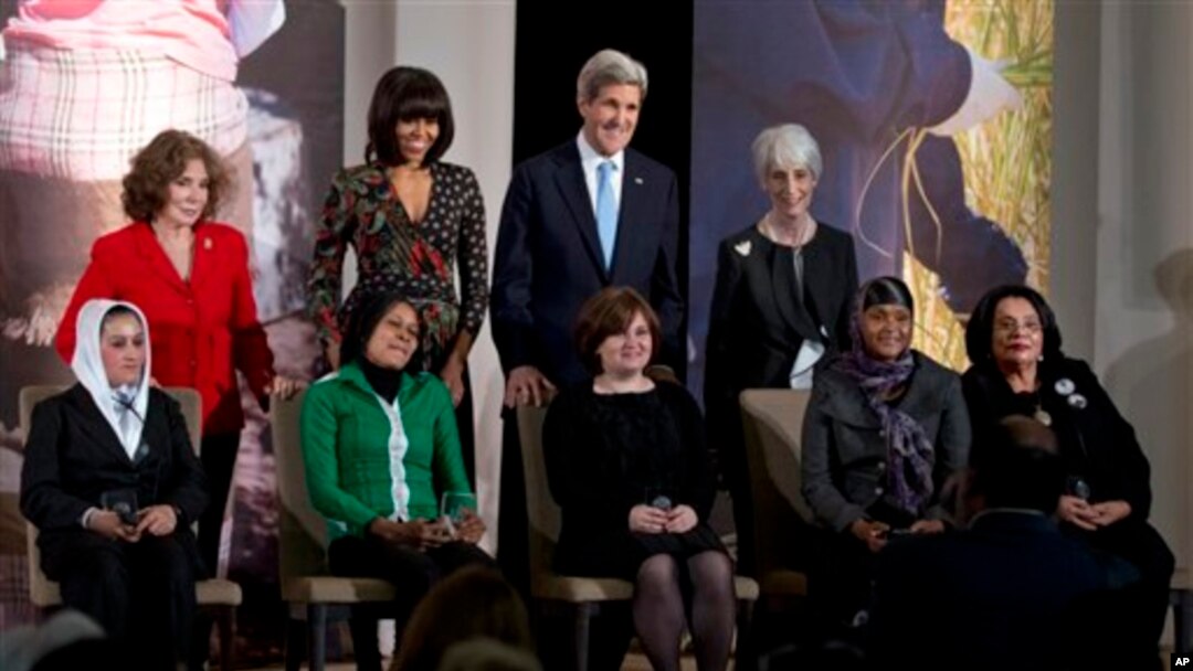 Ibu Negara Michelle Obama dan Menlu AS John Kerry bersama para perempuan penerima penghargaan 'Women of Courage' di Deplu AS, Jumat (8/3). 