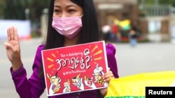 Seorang perempuan menunjukkan hormat tiga jari dan memegang poster melawan kudeta militer Myanmar sebagai bagian dari unjuk rasa Persatuan Teh Susu di Taipei, Taiwan, 28 Februari 2021. (Foto: REUTERS/Ann Wang)