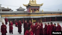 Tibetan monks prepare to attend a prayer meeting for tourists at a temple in Huangnan Tibetan Autonomous Prefecture, Qinghai province, China, July 19, 2012.