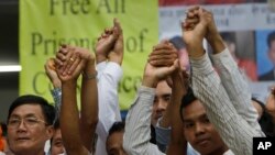 Members of the opposition Cambodia National Rescue Party raise joined hands for photographs at their party headquarters in Phnom Penh, May 27, 2016.