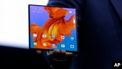 Huawei CEO Richard Yu displays the new Huawei Mate X foldable 5G smartphone at the Mobile World Congress, in Barcelona, Spain, Sunday, Feb. 24, 2019. (AP Photo/Manu Fernandez)