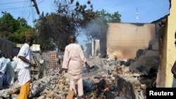 Hai người đàn ông đi giữa đống gạch vụn sau khi những phần tử nổi dậy Boko Haram tấn công Benisheik, phía tây Maidugur, thủ phủ bang Borno, Nigeria.