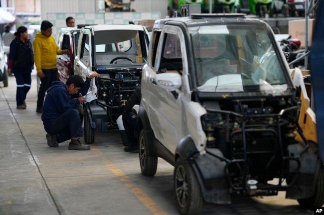 An employee works on a Quantum electric car on an assembly line at a factory in Cochabamba, Bolivia on May 9, 2023. (AP Photo/Juan Karita)