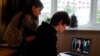 Noah aged 10 and Milly aged 7 watch Britain's Prime Minister Boris Johnson on a laptop during a broadcast to outline plans for gradually easing lockdown measures following the outbreak of the coronavirus disease (COVID-19), Hertford, Britain, May 10, 2020